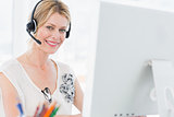 Portrait of a casual woman with headset using computer