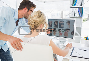 Rear view of photo editors working on computer