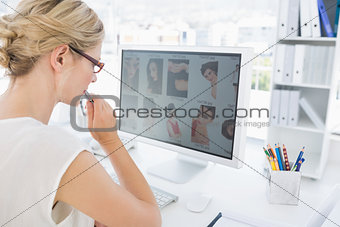 Rear view of a female photo editor working on computer