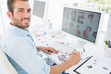 Male photo editor working on computer in a bright office