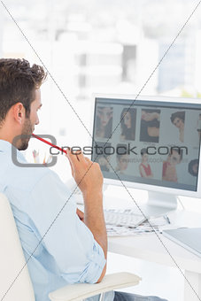Male photo editor working on computer in office