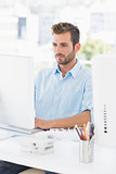 Concentrated man using computer in office