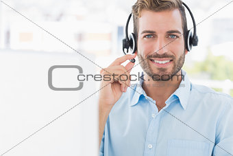Portrait of a young man with headset using computer