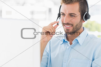 Casual young man with headset using computer