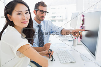 Side view of casual photo editors working on computer