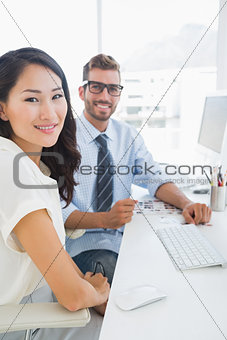 Side view of casual photo editors working on computer