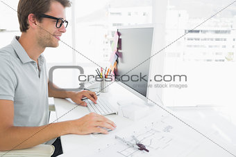 Side view of male photo editor working on computer