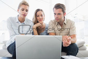 Three people working on computer