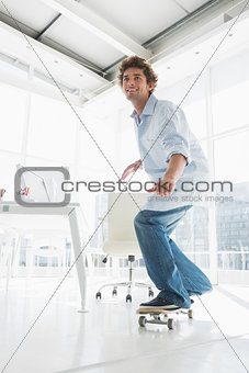 Happy young man skateboarding in office