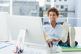 Casual young man with legs on desk in bright office