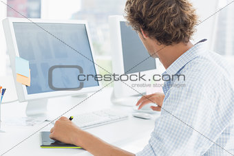 Artist drawing something on graphic tablet with pen