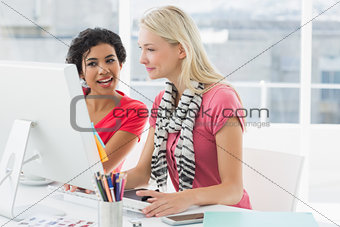 Colleagues using computer in bright office