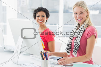 Female colleagues using computer in bright office