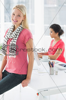 Casual business woman with colleague using computer