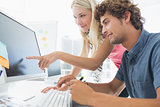 Casual couple using computer in office