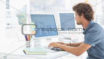 Casual young man using computer in office