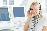Smiling casual young woman with headset in office