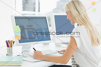 Casual young woman using computer in office