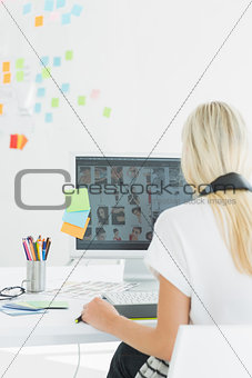 Rear view of a woman using computer in office