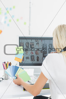 Rear view of casual woman using computer in office