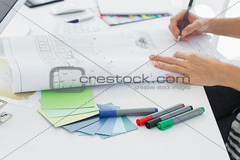 Artist drawing something on paper with pen at office