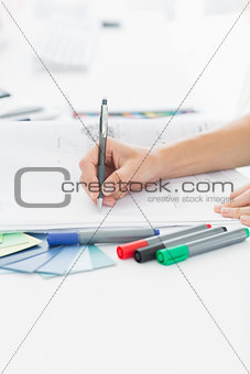 Artist drawing something on paper with pen at office