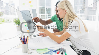 Casual couple using computer in office
