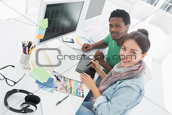 Artist with colleague drawing something on graphic tablet