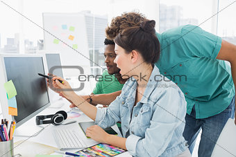 Three artists working on computer at office