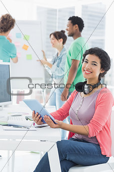 Casual woman with group of colleagues behind in office