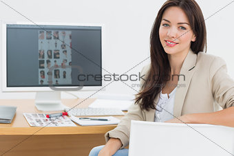 Female artist sitting at desk with computer in office