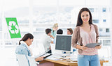 Female artist holding digital tablet with colleagues in background at office