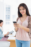 Portrait of a smiling casual young woman text messaging