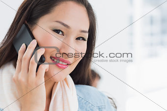 Beautiful casual young woman using mobile phone in office