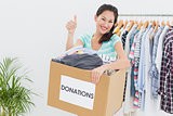 Woman with clothes donation gesturing thumbs up