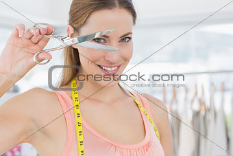 Closeup of a beautiful female fashion designer holding scissors
