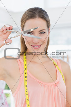 Beautiful female fashion designer holding scissors