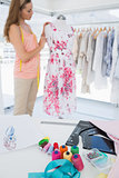 Female fashion designer working on floral dress at studio