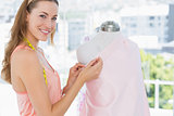 Female fashion designer working on pink fabric