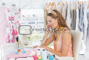 Young female fashion designer using phone