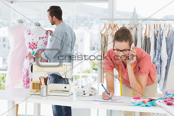 Fashion designers at work in bright studio