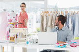 Man using laptop with fashion designer working at studio