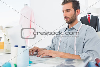 Young male fashion designer using laptop
