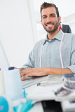 Smiling young male fashion designer using laptop