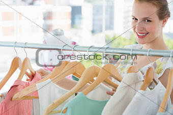 Happy female customer selecting clothes in store