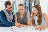 Three fashion designers discussing designs