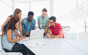 Young casual people using laptop in office