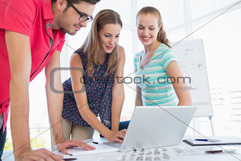 Casual business people using laptop in office