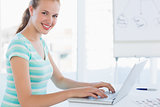 Side view portrait of a young casual woman using laptop