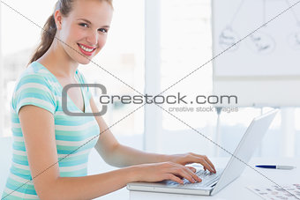 Side view portrait of a young casual woman using laptop